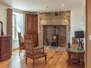 a living room with a stone fireplace and a table at 4 Bed in Grantown on Spey CA027 in Grantown on Spey