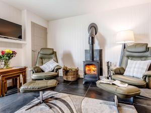 a living room with chairs and a wood stove at 1 Bed in Combe Martin 77349 in Loxhore