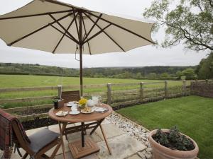 a table with an umbrella on a patio at 1 Bed in Goathland G0157 in Goathland