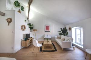 Una sala de estar con un sofá blanco y una mesa. en Superbe appartement, hypercentre, 4chambres., en Béziers