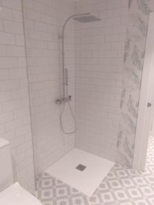 y baño con ducha y suelo de baldosa blanca. en Apartamento moderno de 70 metros a 300 metros de la playa, en Valencia