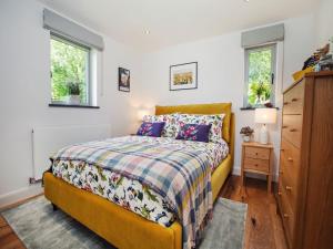 a bedroom with a yellow bed and two windows at 3 bed in Harrogate 77577 in Timble