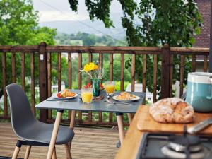 a table with plates of food and drinks on a deck at 1 bed property in Gilwern Brecon Beacons 75206 in Gilwern