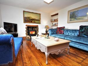 a living room with blue couches and a fireplace at 3 Bed in Llandovery 76381 in Ystrad-ffin