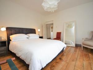 a bedroom with a large white bed and a chair at 3 Bed in Llandovery 76381 in Ystrad-ffin