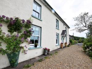 Una casa blanca con flores a un lado. en 3 Bed in Llandovery 76381, en Ystrad-ffin