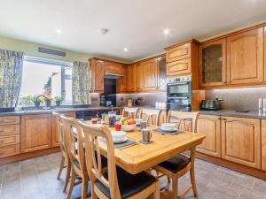 a kitchen with a wooden table and wooden cabinets at 3 Bed in Dumfries 77430 in Auldgirth