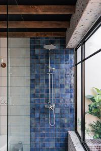 een douche in een badkamer met blauwe tegels bij DESIGNER'S 2BR APARTMENT - SLIEMA FERRIES in Sliema