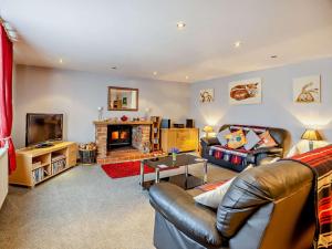 sala de estar con sofá de cuero y chimenea en 2 bed in Donna Nook 74152, en North Somercotes