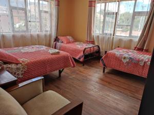 um quarto com duas camas, um sofá e janelas em Goldenball em Cochabamba