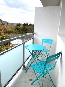 Duas cadeiras e uma mesa numa varanda em Grand 2 chambres & parking em Besançon