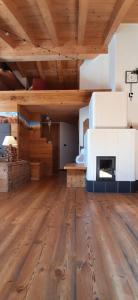 a large room with a fireplace in a wooden ceiling at Berg Apartments - Appartamento famigliare moderno in Stava