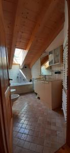 a large bathroom with a sink and a tub at Berg Apartments - Appartamento famigliare moderno in Stava