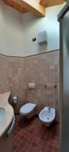 a bathroom with a toilet and a sink at Berg Apartments - Appartamento famigliare moderno in Stava