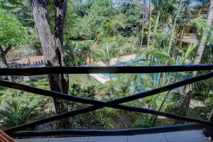 uma vista para um jardim a partir de uma janela em Pousada Villa N'kara em Itacaré