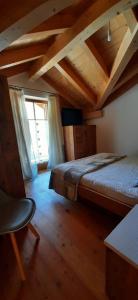 a attic room with two beds and a window at Berg Apartments - Appartamento famigliare moderno in Stava