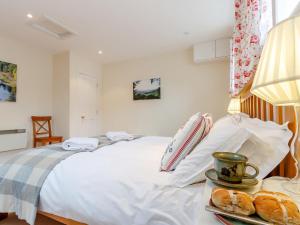 Schlafzimmer mit einem weißen Bett und einem Tablett mit Gebäck in der Unterkunft 1 Bed in Blacklunans CA361 in Cray