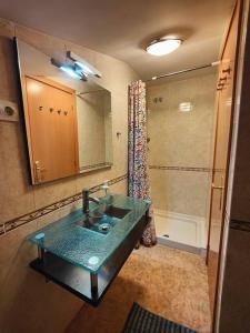 een badkamer met een groene wastafel en een douche bij First sea line nice duplex with terrace in Arenys de Mar