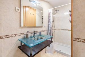 een badkamer met een blauwe wastafel en een douche bij First sea line nice duplex with terrace in Arenys de Mar +30 foto's