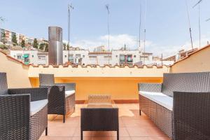 een rij stoelen en tafels op een dak bij First sea line nice duplex with terrace in Arenys de Mar