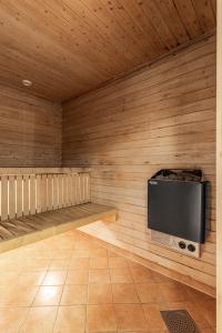 a room with a flat screen tv on a wooden wall at Tinden Apartments in Hemsedal