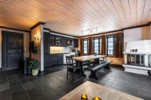 una cucina con soffitto in legno e tavolo in legno di Tinden Apartments a Hemsedal