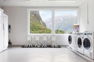 a laundry room with a window and washing machines at Trolltunga Hostel in Tveit