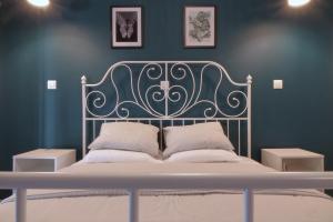 a bed with a metal headboard in a blue bedroom at You & Me Cozy Apartments in Athens