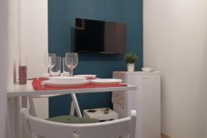 uma mesa com dois copos de vinho e um frigorífico em You & Me Cozy Apartments em Atenas