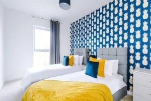 Duas camas num quarto com uma parede azul e branca em 2 Bedroom Manchester Gem Ancoats em Manchester