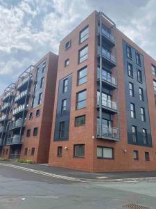 a large brick building with balconies on a street at 2 Bedroom Manchester Gem Ancoats in Manchester