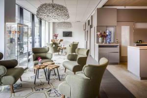 a waiting room with chairs and tables and windows at Babylon Hotel Den Haag in The Hague