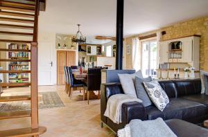 ein Wohnzimmer mit einem Sofa und einem Esszimmer in der Unterkunft Les Charmes de Carlucet Gite-Beaux Reves in Saint-Crépin-et-Carlucet