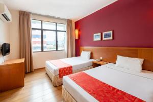 um quarto de hotel com duas camas e uma janela em Victoria Inn, Penang em George Town