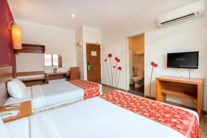 a hotel room with two beds and a television at Victoria Inn, Penang in George Town