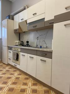 a kitchen with white cabinets and stainless steel appliances at Flat in Chisinau in Chişinău