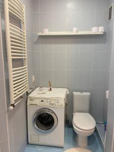 a bathroom with a washing machine and a toilet at Flat in Chisinau in Chişinău