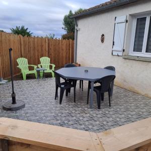 a black table and chairs on a patio at LES BOUCHOLEURS in Yves