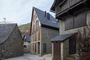 un antiguo edificio de piedra con una puerta en un patio en Val Arties 1 by FeelFree Rentals, en Arties