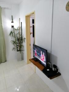 sala de estar con TV de pantalla plana sobre una mesa en La Residence Emmaüs, en Rodrigues Island