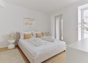 a white bedroom with a white bed and a window at Stylish & Modern Apartment - Private Garden & Free Parking in Vienna
