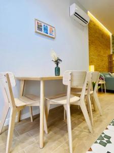 uma mesa de jantar e cadeiras com um vaso em Cabanyal Room 5 - New & Stylish by the Beach em Valência