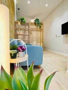 uma sala de estar com um sofá azul e vasos de plantas em Cabanyal Room 5 - New & Stylish by the Beach em Valência