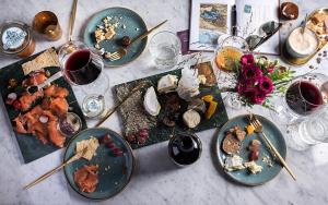 einen Tisch mit Teller mit Speisen und Gläsern Wein in der Unterkunft Chalet Antoine serviced Apartments by Mirabeau in Zermatt
