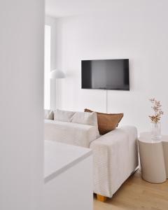 a living room with a couch and a tv on a wall at Stylish & Modern Apartment - Private Garden & Free Parking in Vienna