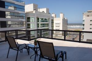 einen Balkon mit Stühlen und einem Tisch auf einem Gebäude in der Unterkunft Flipper Hotel in Laguna