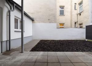 an empty sidewalk in front of a building at Stylish & Modern Apartment - Private Garden & Free Parking in Vienna