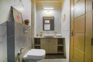 a bathroom with a toilet and a sink at SaffronStays Edelweiss Estate in Rānīkhet
