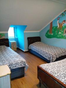 ein Schlafzimmer mit zwei Betten und einem Gemälde an der Wand in der Unterkunft Taqnvac hrashq in Dilidschan