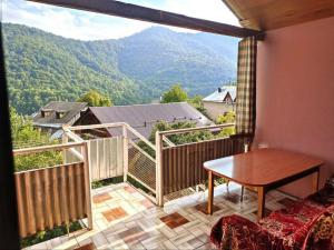 a balcony with a table and a view of the mountains at Taqnvac hrashq in Dilijan
